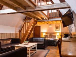 a living room with leather furniture and a loft at Hotel Monasterium PoortAckere Ghent in Ghent