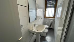a white bathroom with a sink and a toilet at BnB Arianna's home in Turin