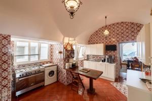 a kitchen with a table and a stove top oven at Villa Le Tuie by Elite Villas in Capri