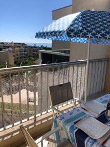 stół i parasol na balkonie w obiekcie Charmant studio à Cros de Cagnes w Cagnes-sur-Mer