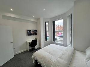 um quarto com uma cama, uma secretária e uma janela em Regent Cosy em Coventry