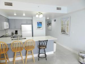a kitchen with a counter and three bar stools at 1 BR Resort Condo Direct Oceanfront Wyndham Ocean Walk - Daytona Funland 1307 in Daytona Beach