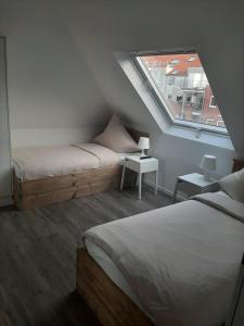 Schlafzimmer im Dachgeschoss mit 2 Betten und einem Fenster in der Unterkunft Pension Asche in Münster