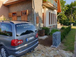 samochód zaparkowany przed domem w obiekcie Titi Boutique Apartmanok w Bukfurdo