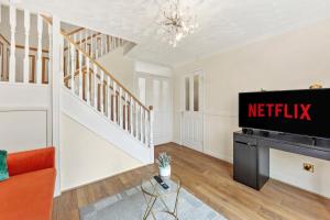 een woonkamer met een netflix-bord aan de muur bij luxury 6 bedroom house in Aylesbury, Free parking in Buckinghamshire