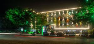 un edificio con coches aparcados delante de él por la noche en Club Central, en Bolpur