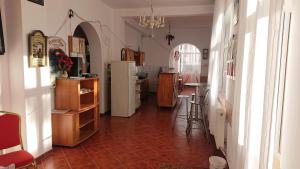 a room with a kitchen and a hallway with a refrigerator at vila strugurelu hostel in Predeal