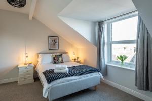 sypialnia z łóżkiem i oknem w obiekcie Stunning 5 Bedroom 5 En-Suite Victorian House in Harrogate w mieście Harrogate