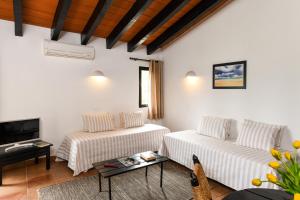 a living room with two white couches and a tv at Pedras D'el Rei in Tavira