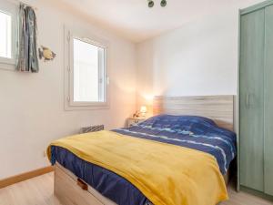 1 dormitorio con 1 cama con manta amarilla y azul en Apartment La Louisiane by Interhome, en Château-dʼOlonne