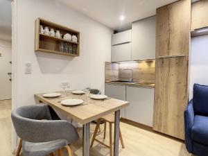 Apartment Chavière-12 by Interhome في ليه مينوير: مطبخ وغرفة طعام مع طاولة وكراسي