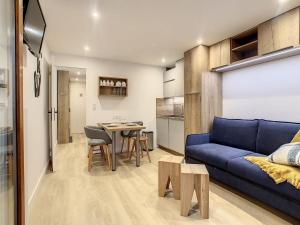 a living room with a blue couch and a table at Apartment Chavière 716 by Interhome in Les Menuires