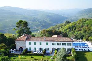 a house on a hill with a view of a valley at Relais San Maurizio in Santo Stefano Belbo