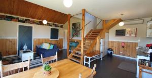 Una habitación con una mesa de comedor y una escalera en una casa en Buln Buln Cabins, en Yanakie