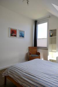 ein Schlafzimmer mit einem Bett, einem Stuhl und einem Fenster in der Unterkunft Ferienwohnung Woldemar in Detmold
