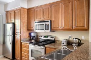 a kitchen with wooden cabinets and a stove and microwave at Santa Clara 1BR w Gym Pool WD SFO-641 in Santa Clara