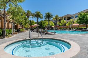 a pool at a resort with tables and umbrellas at Santa Clara 1BR w Gym Pool WD SFO-641 in Santa Clara