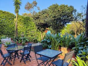 een patio met tafels en stoelen in een tuin bij Quinta Minuvida in Rabo de Peixe