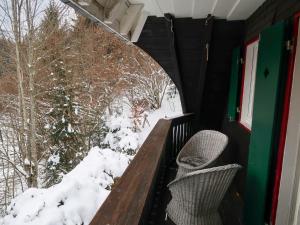 un balcón con 2 sillas y nieve en el suelo en Holiday Home Kesslerberg by Interhome, en Hinterzarten