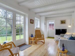 ein Wohnzimmer mit einem Sofa und einem Tisch in der Unterkunft Holiday Home Tabetha - 25m from the sea in Sealand by Interhome in Tisvildeleje