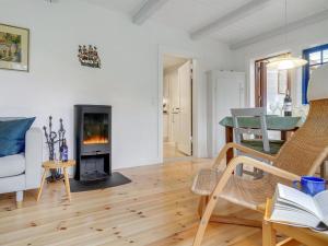 ein Wohnzimmer mit einem Kamin und einem Tisch in der Unterkunft Holiday Home Tabetha - 25m from the sea in Sealand by Interhome in Tisvildeleje