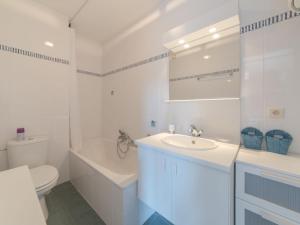 La salle de bains blanche est pourvue de toilettes et d'un lavabo. dans l'établissement Studio Green Garden-7 by Interhome, au Coq