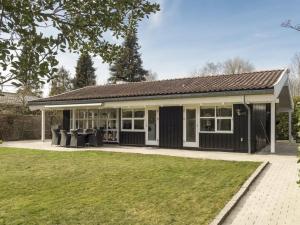 ein Haus mit einer schwarz-weißen Fassade in der Unterkunft Holiday Home Cedomir - 625m from the sea in Sealand by Interhome in Hornbæk