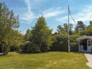 a flag pole in a yard with a gazebo at Holiday Home Cedomir - 625m from the sea in Sealand by Interhome in Hornbæk