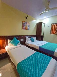 2 łóżka w pokoju hotelowym w kolorze niebieskim i białym w obiekcie Hotel Amber-colaba w Bombaju