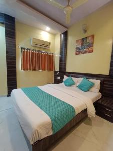 Hotel Amber-colaba في مومباي: غرفة نوم بسرير كبير مع وسائد زرقاء