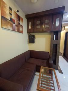 a living room with a couch and wooden cabinets at Hotel Amber-colaba in Mumbai