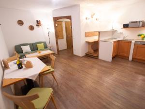 een woonkamer met een tafel en stoelen en een keuken bij Apartment Koa Sünd by Interhome in Pfarrwerfen