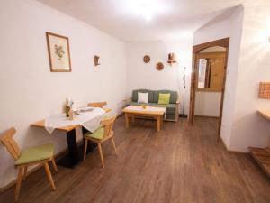 een woonkamer met een tafel en stoelen en een bank bij Apartment Koa Sünd by Interhome in Pfarrwerfen