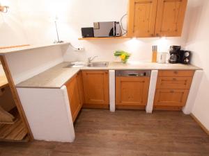 een kleine keuken met houten kasten en een wastafel bij Apartment Koa Sünd by Interhome in Pfarrwerfen