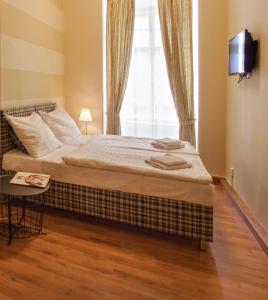 a bedroom with a bed with a television and a window at Residence Corto Old Town in Prague