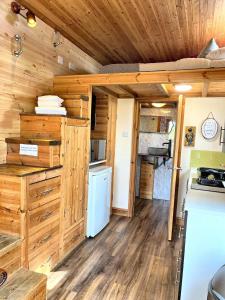 a kitchen and living room in a log cabin at Tiny House-Hot Tub-St Clears-Pembrokeshire-Tenby in Carmarthen