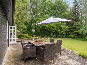 a table and chairs with an umbrella on a patio at Holiday Home Ilena - 16-3km from the sea in Sealand by Interhome in Borup
