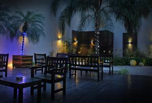 ブエノスアイレスにあるPalermo Suites Buenos Aires Hotel & Apartmentsの夜のベンチとヤシの木のあるパティオ