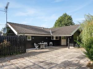 a house with a fence and a patio at Holiday Home Eivor - 500m from the sea in Sealand by Interhome in Hornbæk