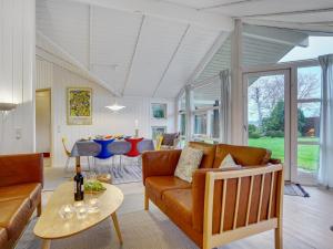 a living room with a couch and a table at Holiday Home Eivor - 500m from the sea in Sealand by Interhome in Hornbæk