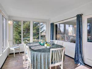 jadalnia ze stołem, krzesłami i oknami w obiekcie Holiday Home Ømund - all inclusive - 600m to the inlet in Sealand by Interhome w mieście Holbæk