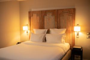 蒙利沃的住宿－Ezia，一间卧室配有一张带白色床单和两盏灯的大床