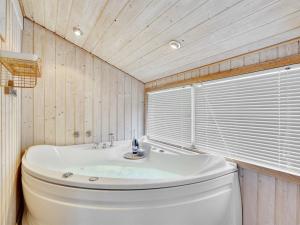 a bathroom with a white toilet and a tub at Holiday Home Rixa - 525m from the sea in Sealand by Interhome in Slagelse