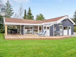 a modular home with a deck and patio at Holiday Home Rixa - 525m from the sea in Sealand by Interhome in Slagelse
