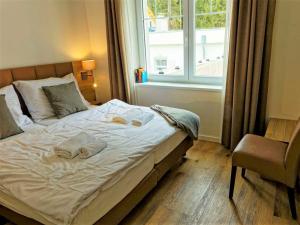 1 cama en un dormitorio con ventana y silla en Apartment Lakeside Village 7 by Interhome, en Frymburk