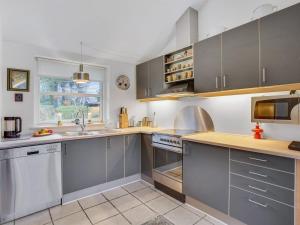 una cocina con electrodomésticos de acero inoxidable y una ventana en Holiday Home Lauren - 200m to the inlet in Sealand by Interhome, en Holbæk