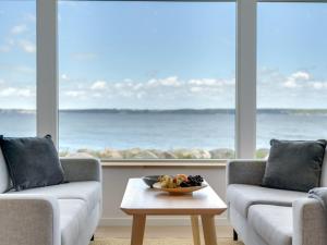 een woonkamer met twee banken en een fruitschaal op een tafel bij Holiday Home Elsabeth - 20m from the sea in Sealand by Interhome in Helsingør