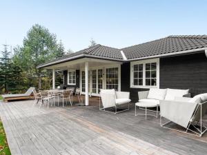 une terrasse avec des chaises, une table et une maison dans l'établissement Holiday Home Hansmine - 150m to the inlet in Sealand by Interhome, à Jægerspris