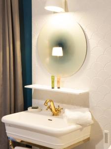 モンリヴォーにあるEziaのバスルーム(金の蛇口と鏡付きの洗面台)