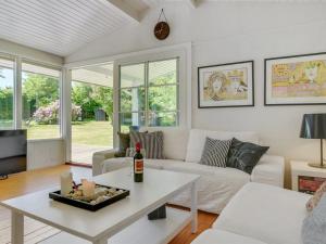 ein Wohnzimmer mit einem weißen Sofa und einem Tisch in der Unterkunft Holiday Home Tobrjön - 200m to the inlet in Sealand by Interhome in Skibby